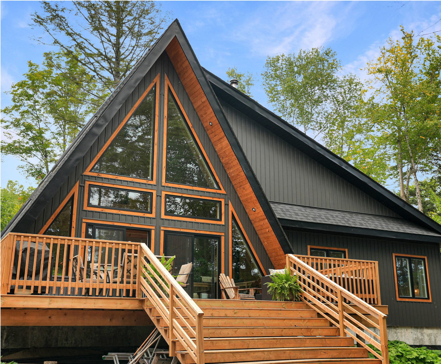 A black house with a wooden deck and stairs