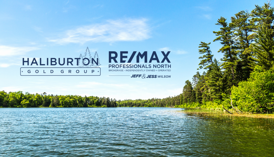 A lake surrounded by trees and a re / max logo