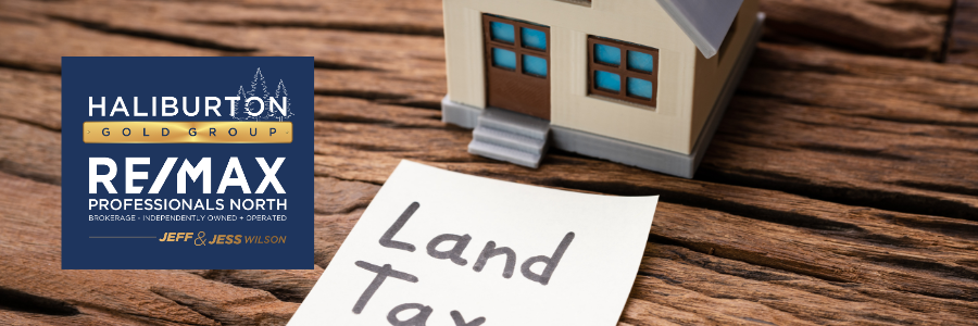A small house is sitting next to a piece of paper that says land tax.