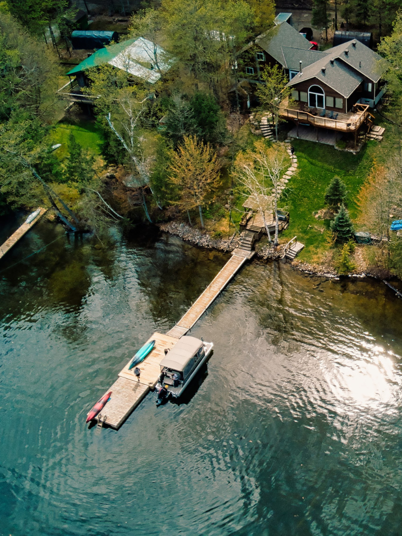 A woman is holding a canadian flag in front of a lake.