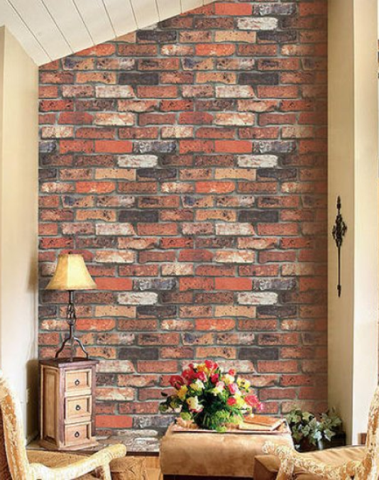 A living room with a brick wall and a table with flowers on it.