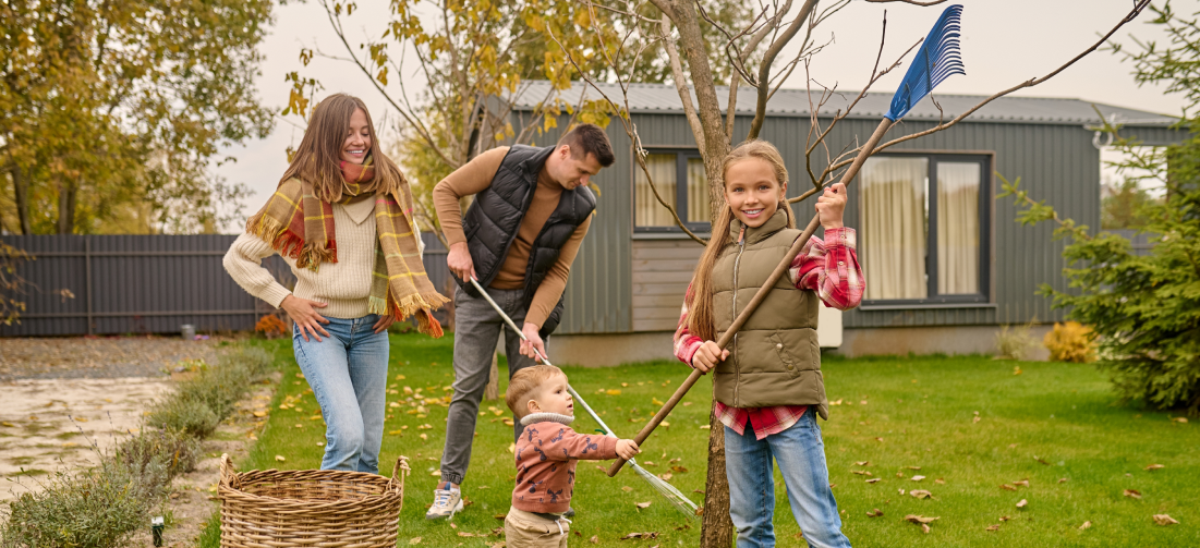 A family is raking leaves in their backyard.