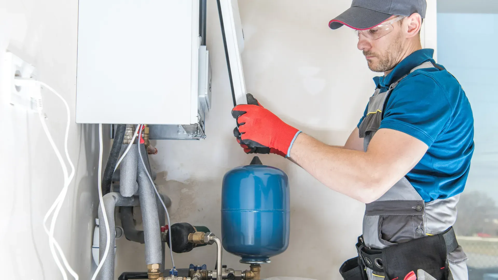 A man is fixing a water heater in a house.