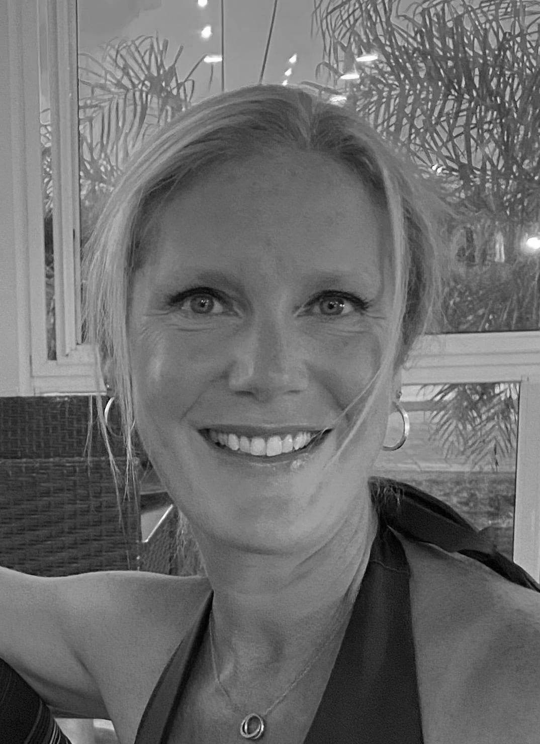 Une femme sourit sur une photo en noir et blanc.