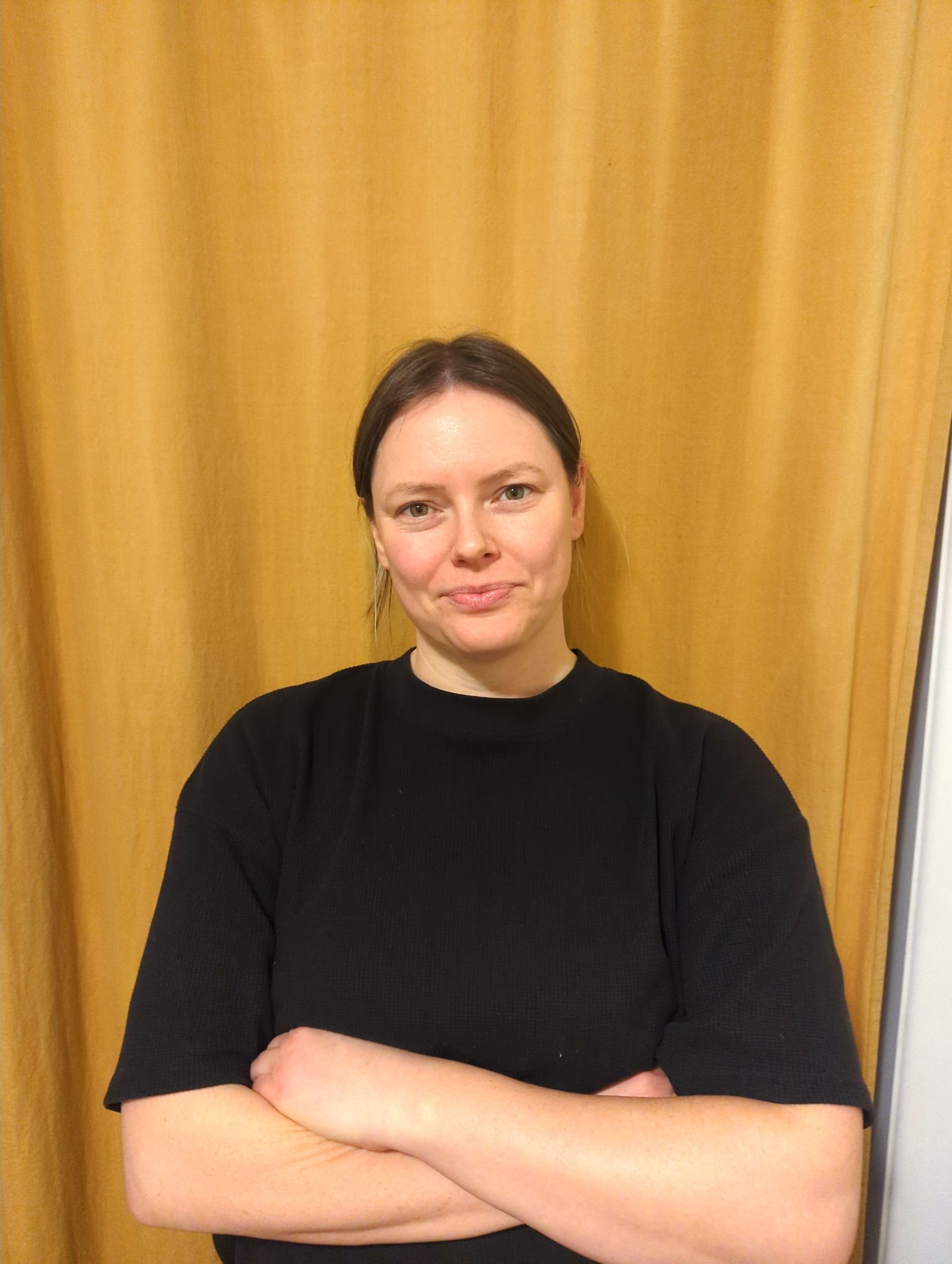 Une femme en chemise blanche sourit sur une photo en noir et blanc.