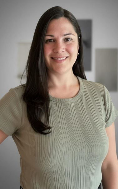 Un homme barbu sourit sur une photo en noir et blanc.