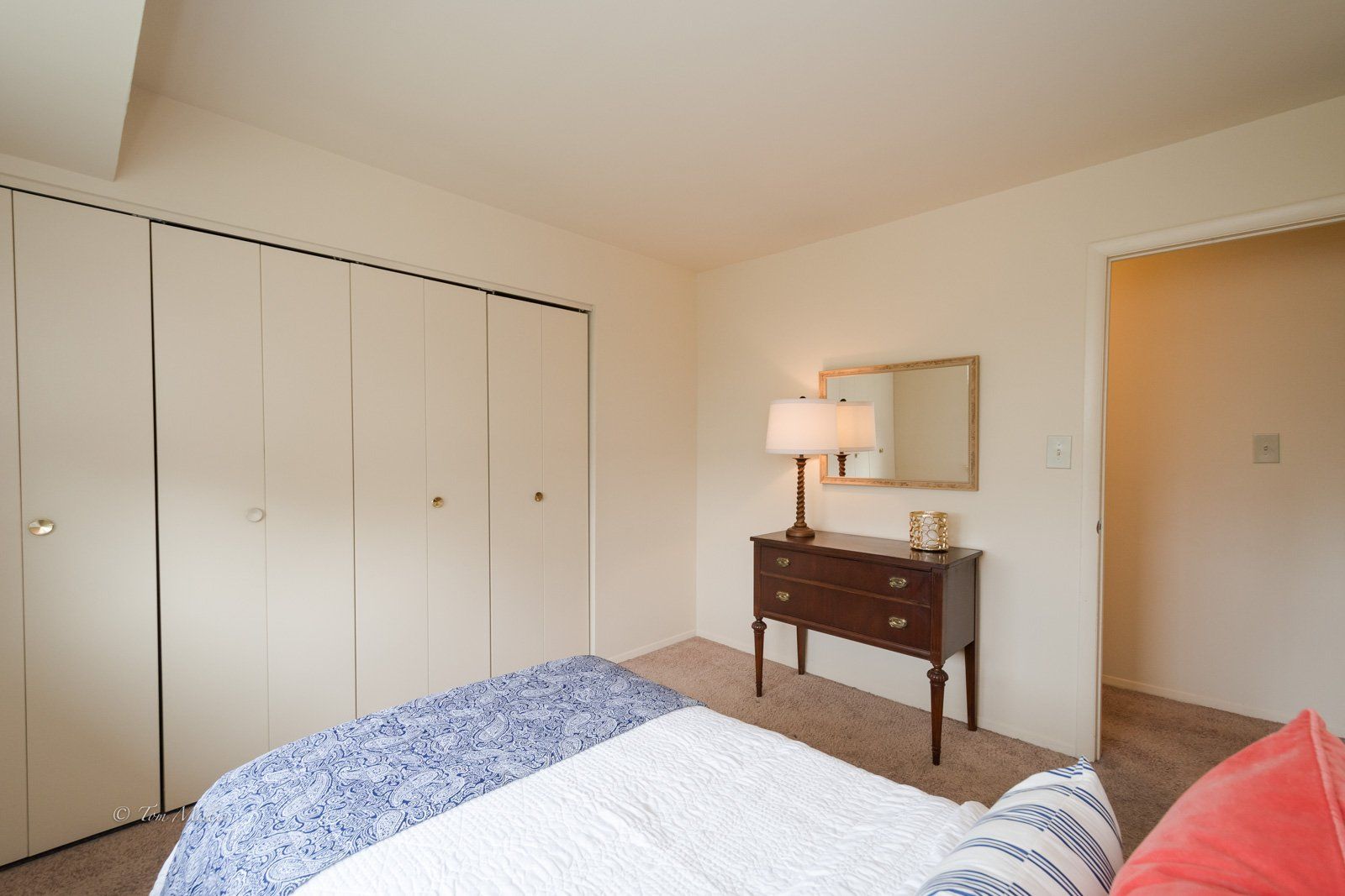 A bedroom with large closet and dresser