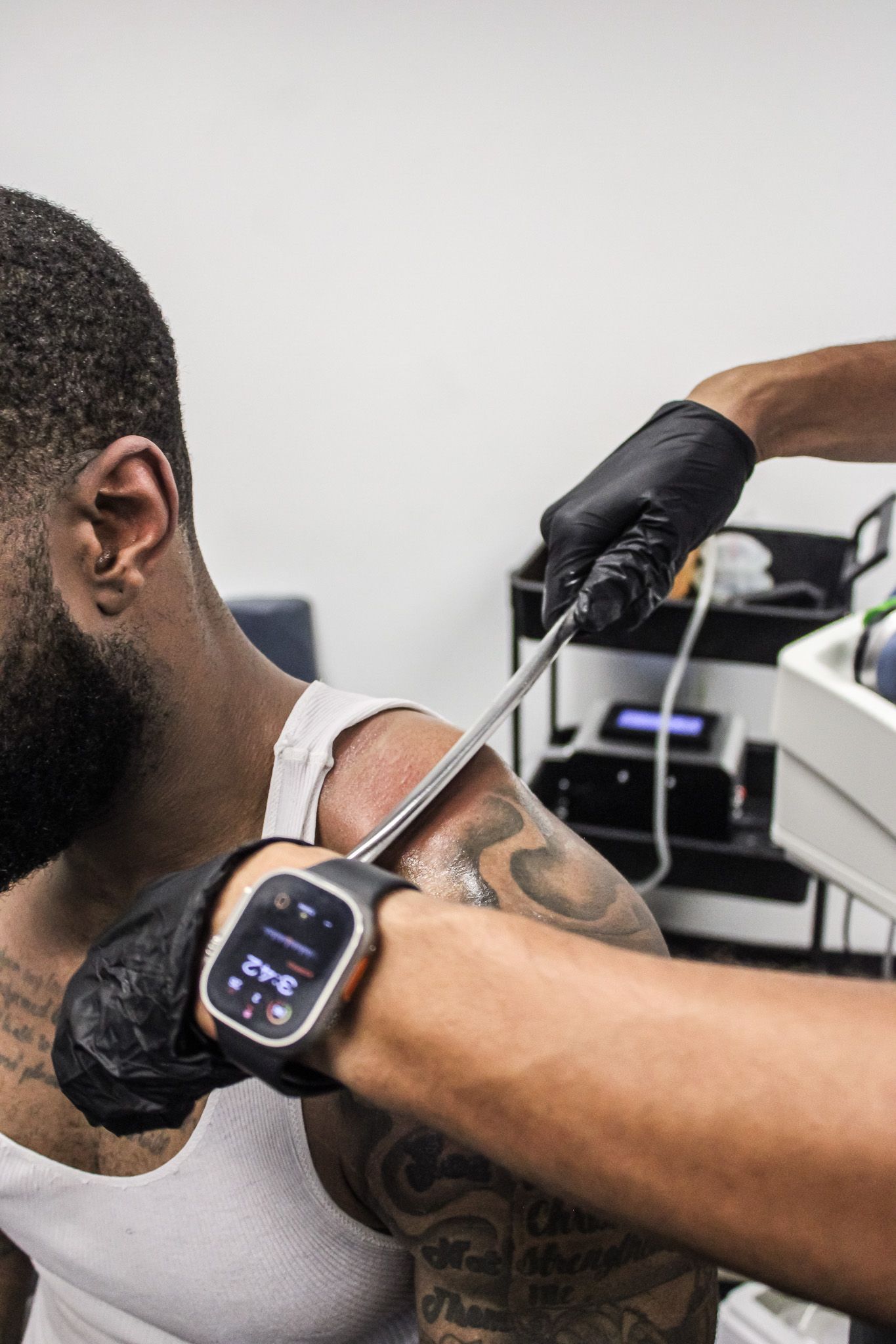A woman is sitting on a yoga mat in a living room.