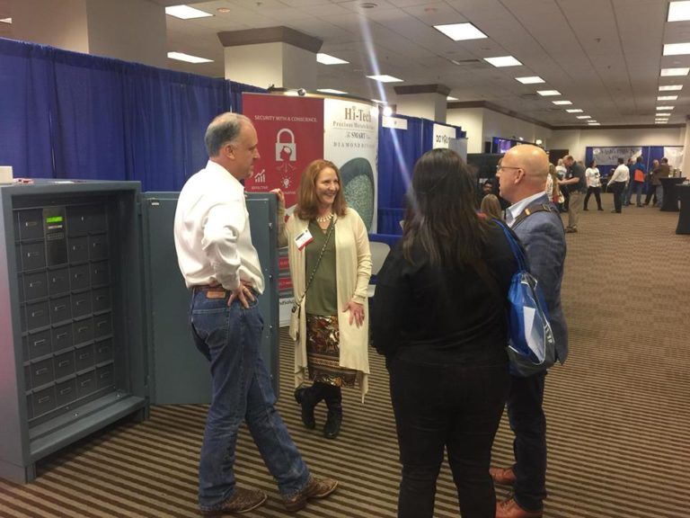 A group of people are standing in a room talking to each other