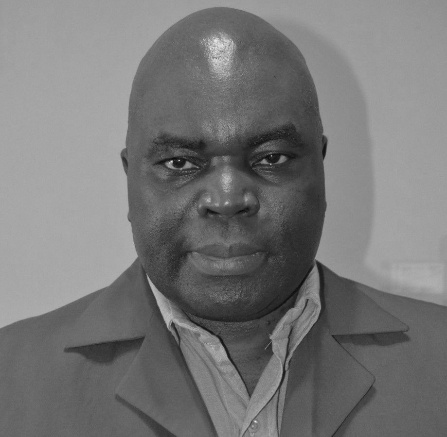 A black and white photo of a man sitting in a chair.