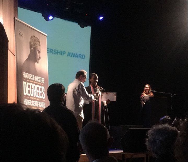 A group of people standing in front of a sign that says degrees