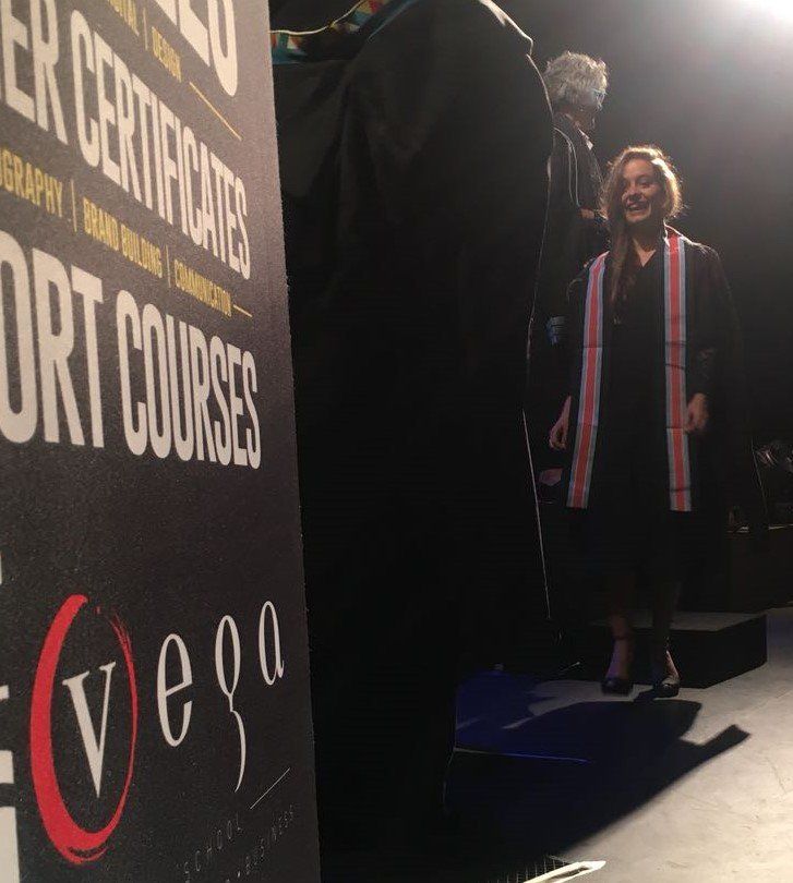 A woman stands in front of a sign that says vega