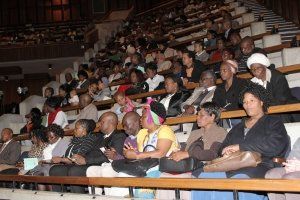 A group of people are sitting in a theater watching a show