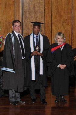 Three people in graduation gowns are posing for a picture