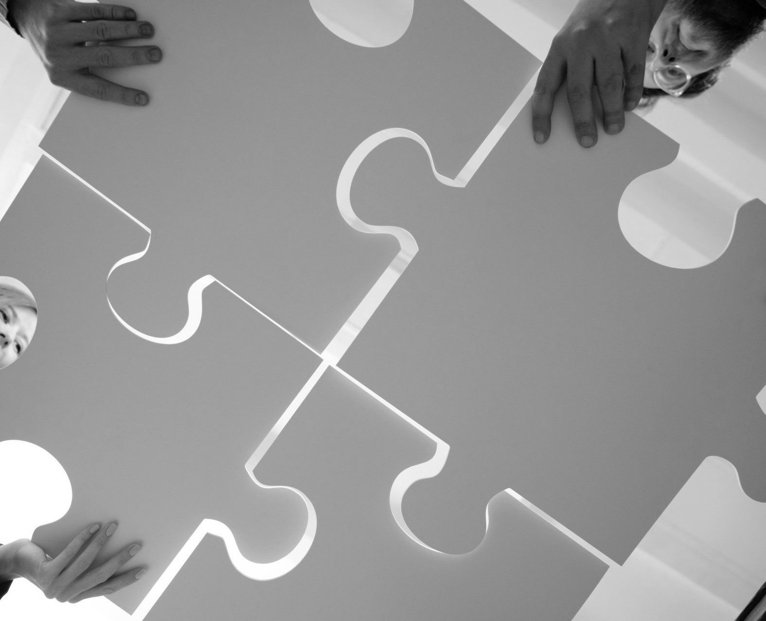 A group of people are putting together a large puzzle piece