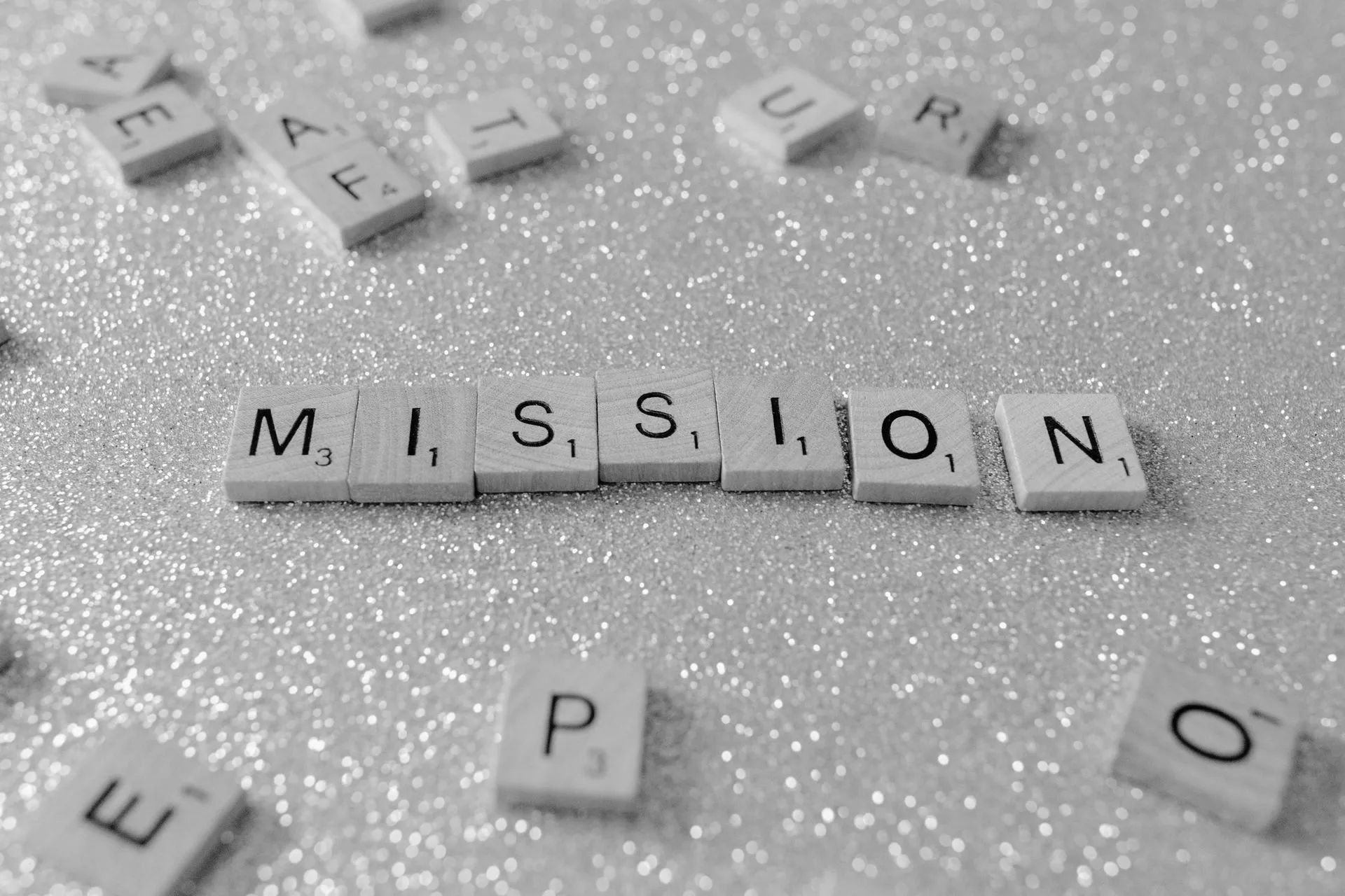 The word mission is written in scrabble tiles
