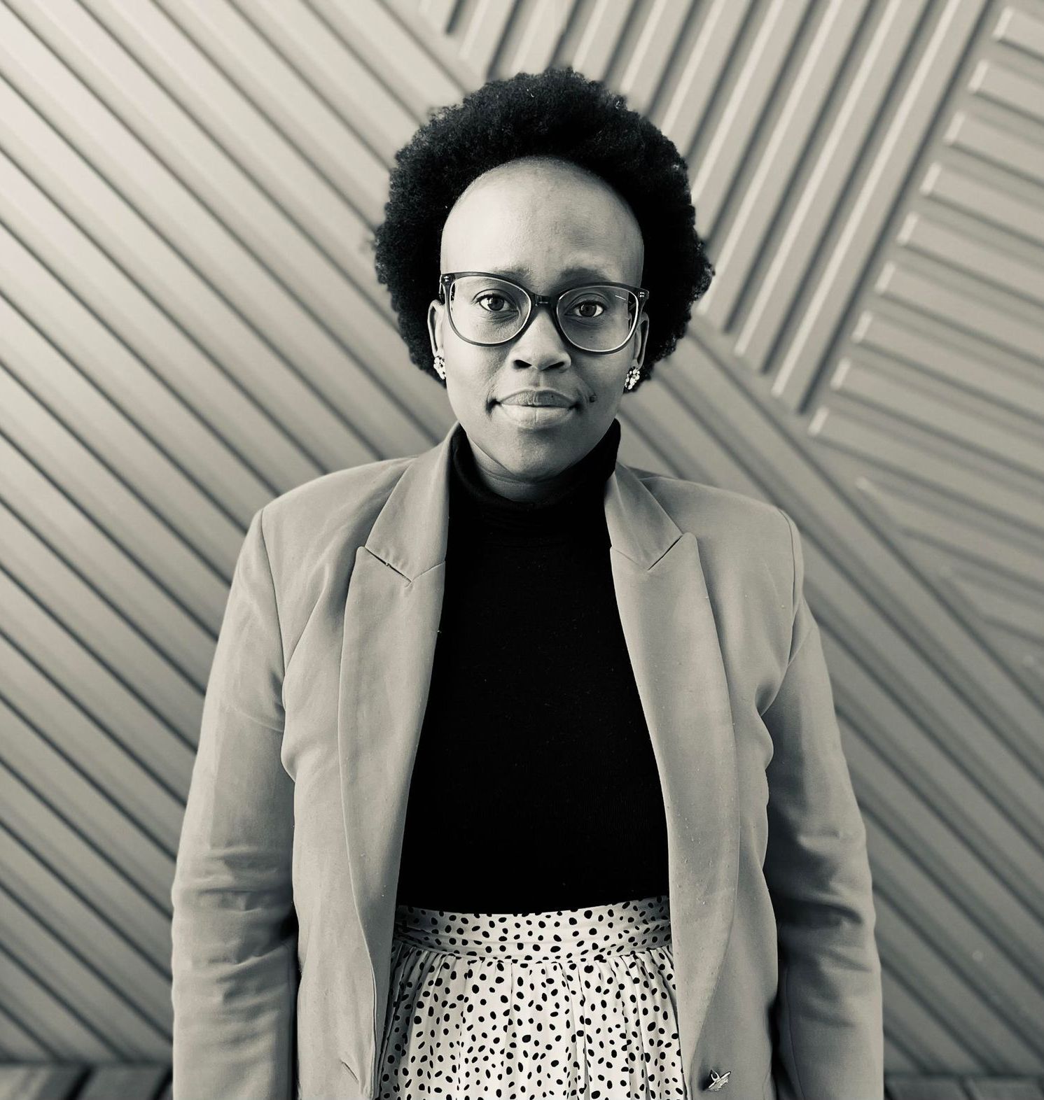 A black and white photo of a woman wearing glasses and a t-shirt.