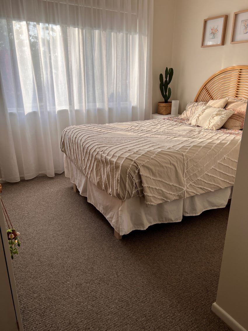 A Bedroom With a Wicker Headboard and a Bed — Aussie Carpets & Vinyl In Sunshine Coast, QLD