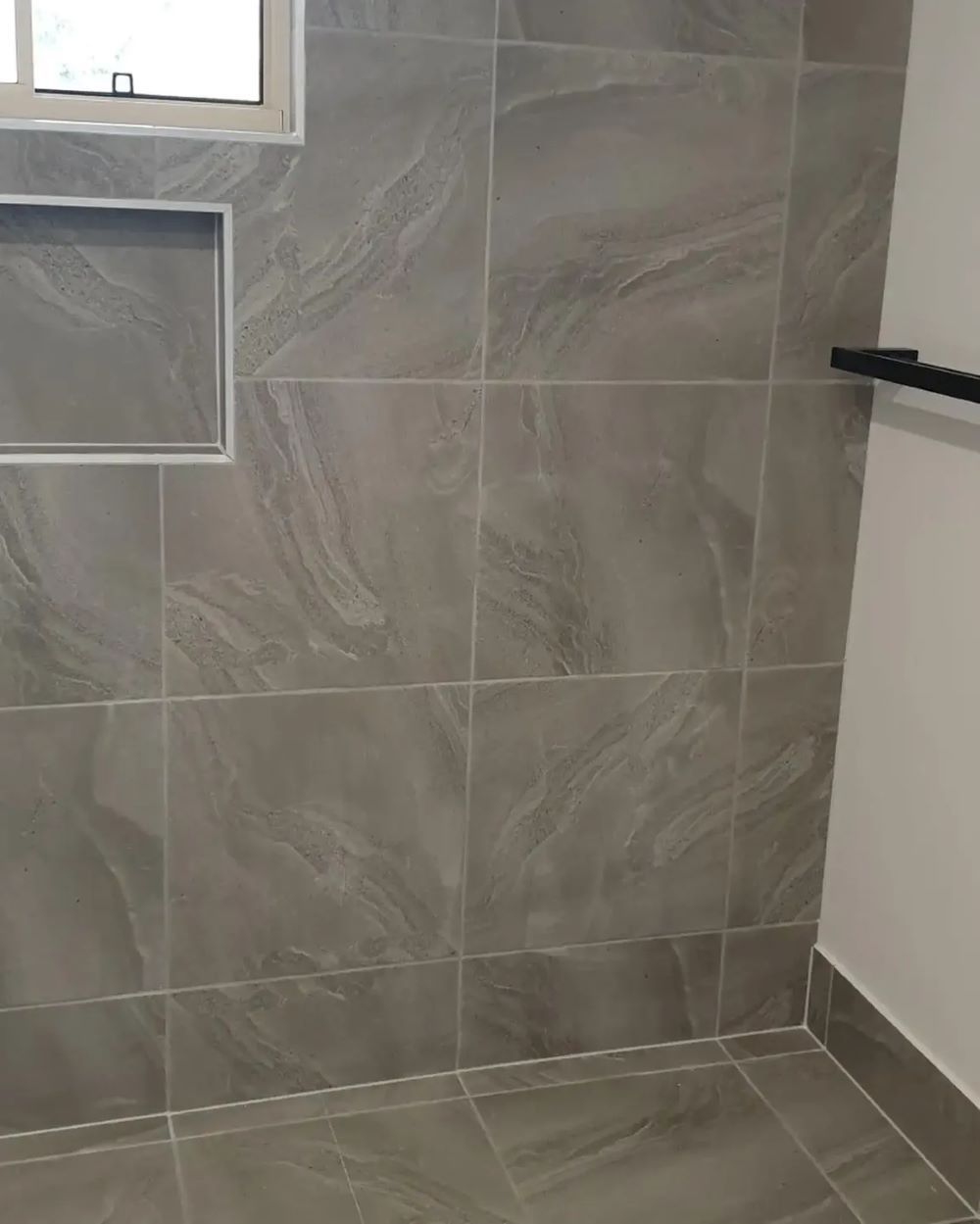 A Bathroom With Gray Tiles and a Window — Aussie Carpets & Vinyl In Beerwah, QLD