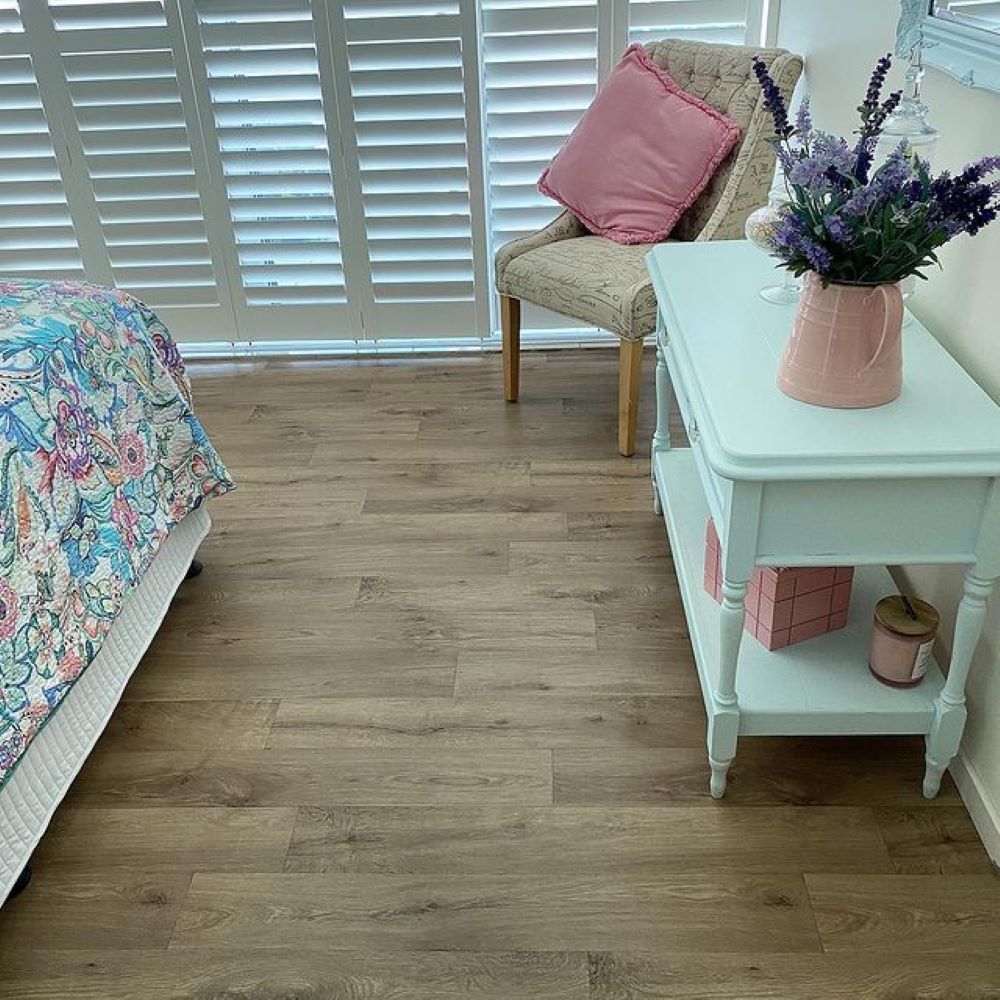 A Bedroom With a Bed, Chair, Table and Vase of Flowers — Aussie Carpets & Vinyl In Maleny, QLD