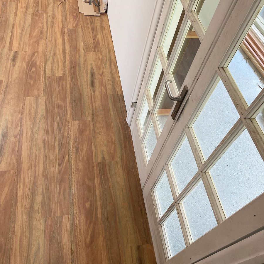 A Room With a Wooden Floor and a White Door — Aussie Carpets & Vinyl In Sunshine Coast, QLD