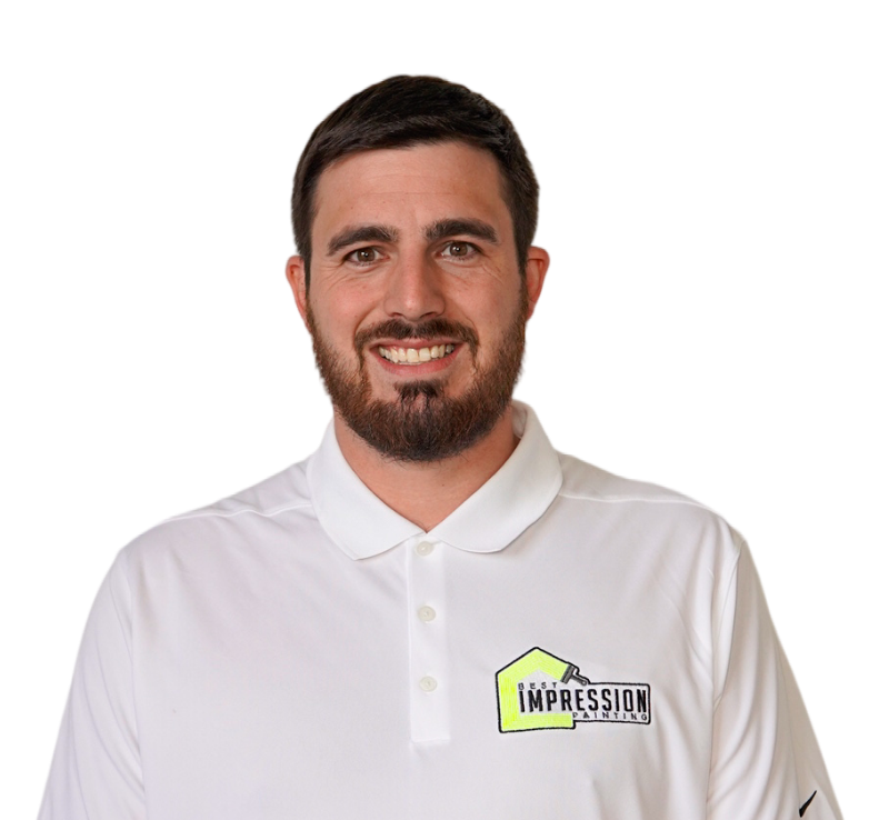 A man with a beard is wearing a white polo shirt that says impression