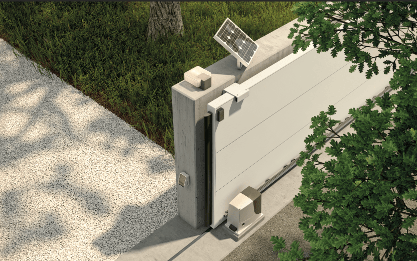 Puerta corrediza automática con panel solar sobre poste de hormigón junto a entrada pavimentada.