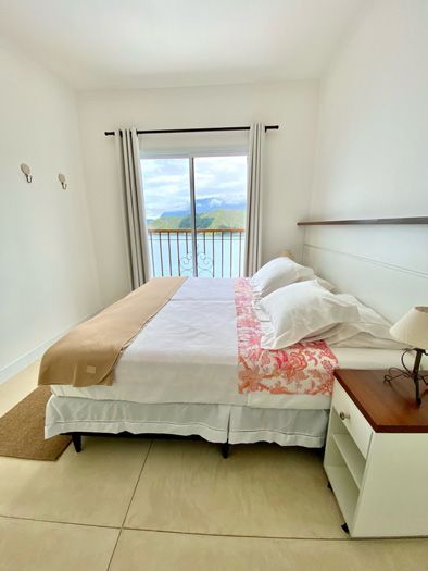 Um quarto com uma cama king size e uma mesa de cabeceira