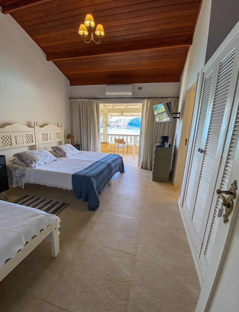 Um quarto com duas camas e uma varanda com vista para o oceano.