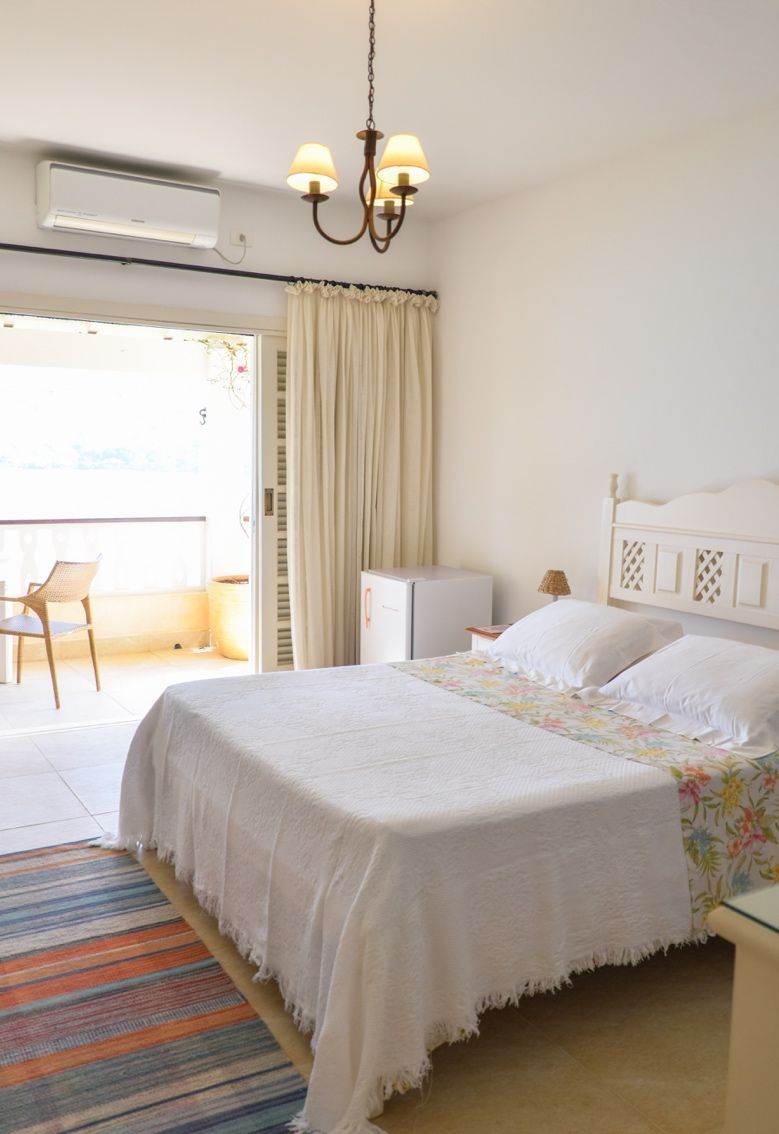 Um quarto com uma cama king size e um lustre.