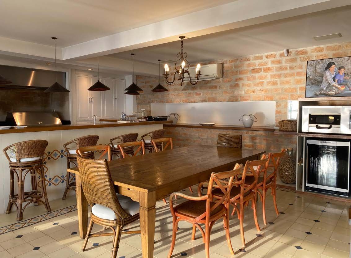 Uma grande sala de jantar com uma mesa e cadeiras de madeira.