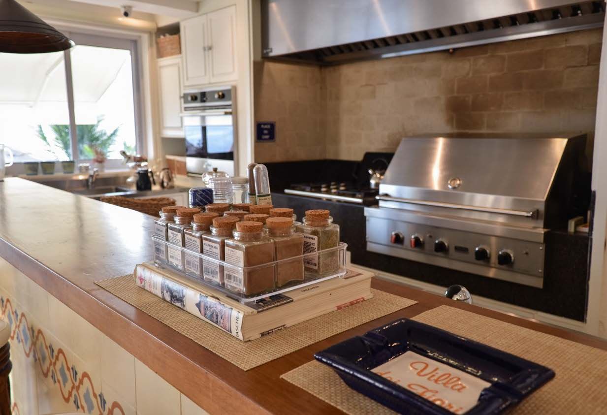 Uma cozinha com uma grelha e uma bandeja de temperos no balcão.