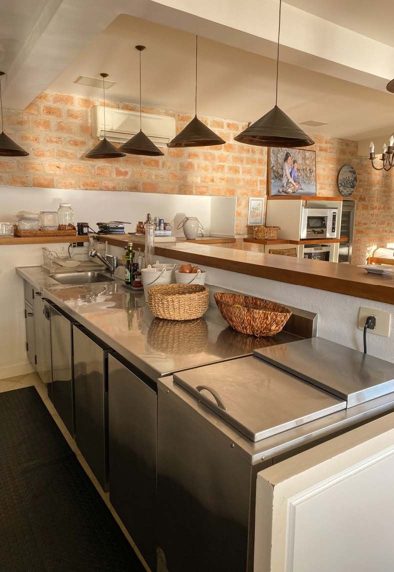 Uma cozinha com eletrodomésticos de aço inoxidável e uma parede de tijolos.