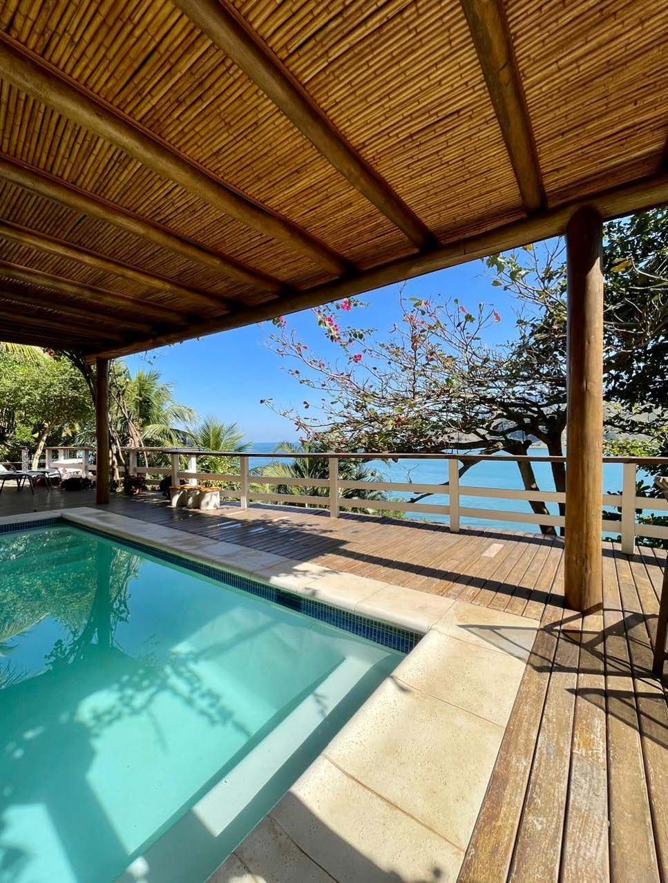 Uma piscina com deck de madeira com vista para o oceano