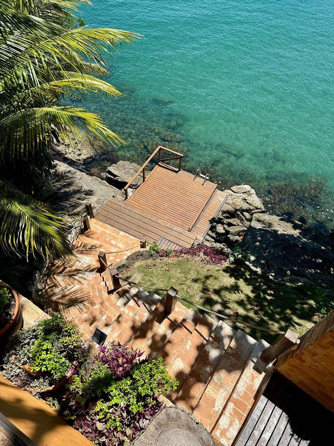 Uma vista de um cais e escadas que levam ao oceano.