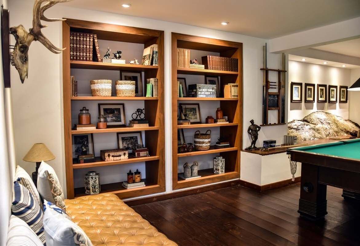 Uma sala de estar com mesa de sinuca e estantes de livros