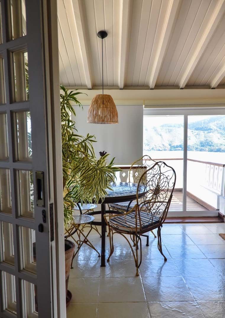 Uma sala de jantar com mesa e cadeiras e uma varanda.