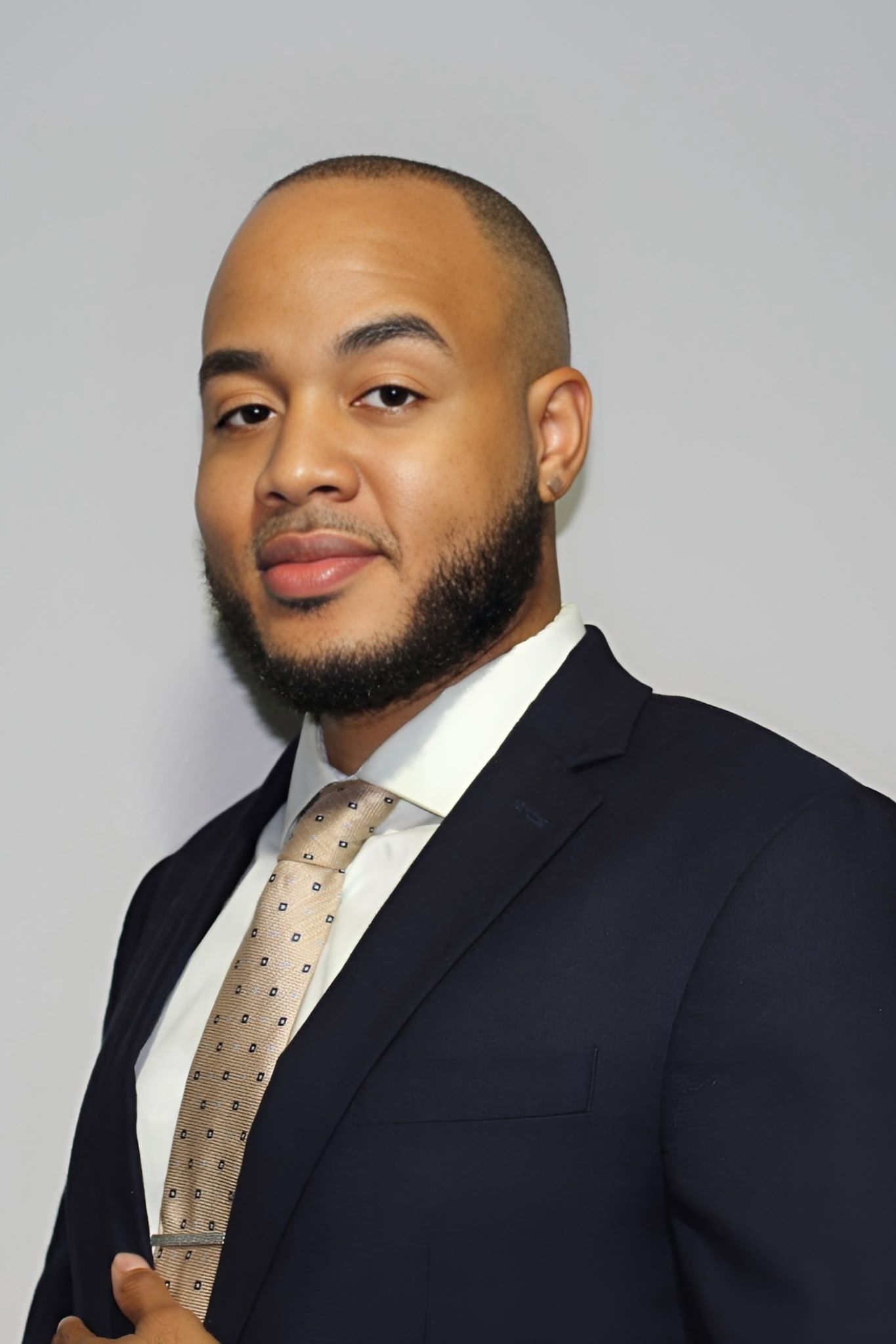 A woman is sitting at a desk with a laptop and a vase of flowers.