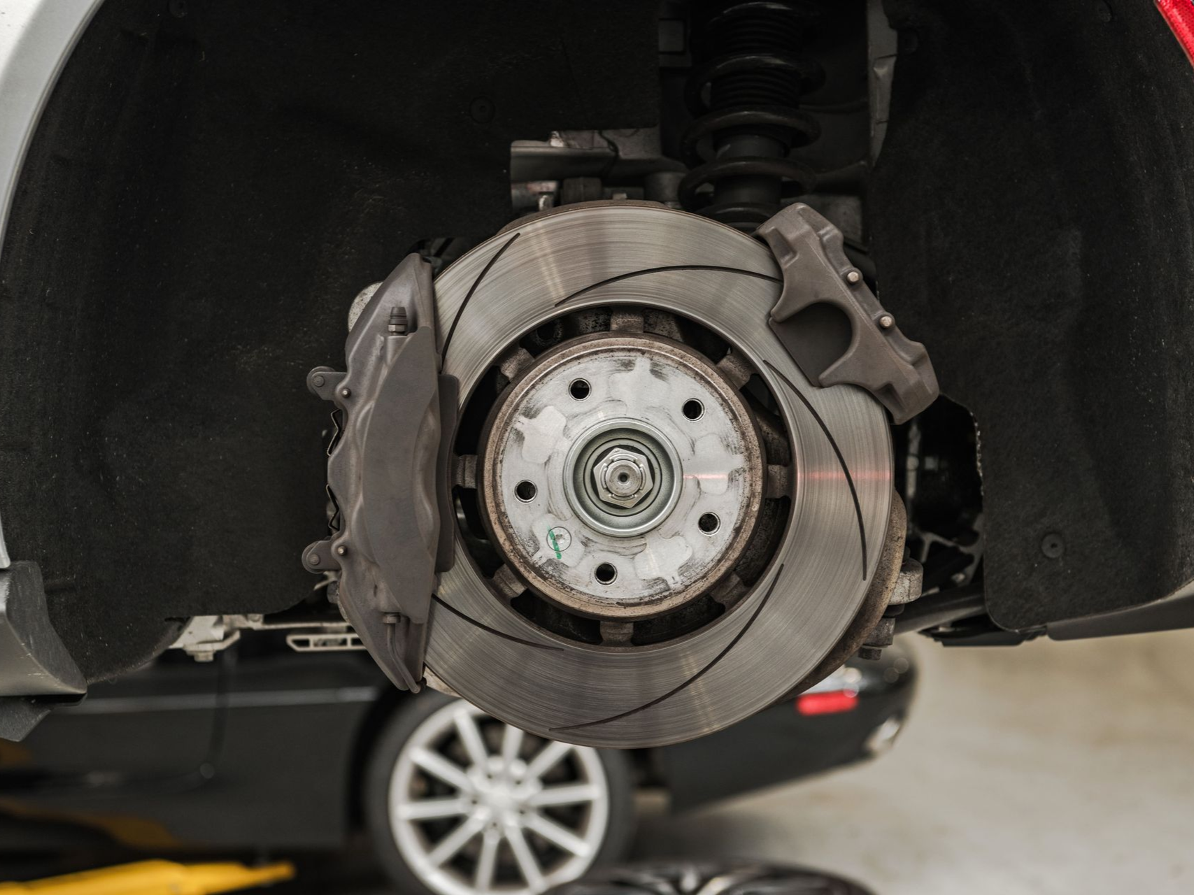 Car brake disc and caliper assembly, showing the rotor, pads, and support structure.