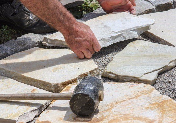 Masonry Contractor Laying Down Stones on Raleigh, NC Property