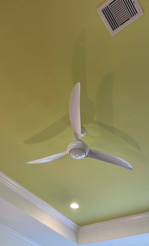 A white ceiling fan is hanging from the ceiling of a room.