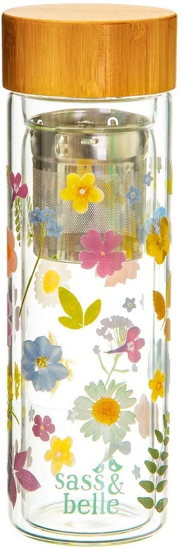 A glass bottle with flowers on it and a wooden lid.