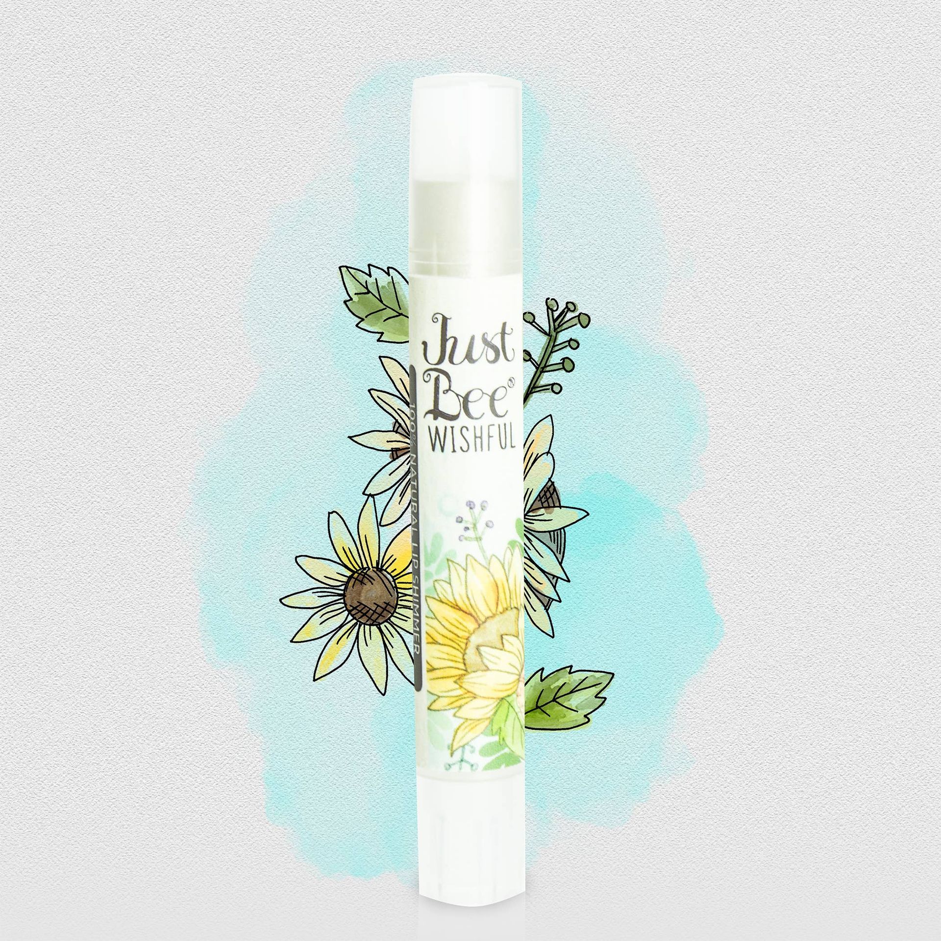 A bottle of just bee wishes lip balm with flowers on it.