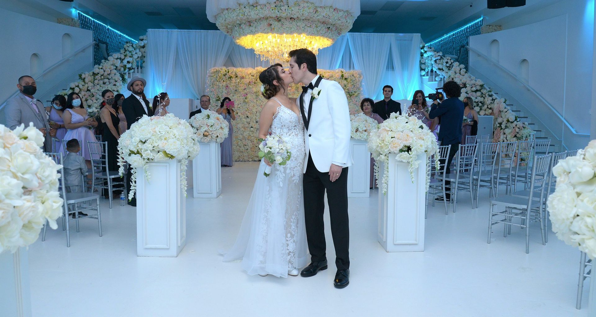 A bride and groom kissing in front of a crowd at their wedding ceremony.