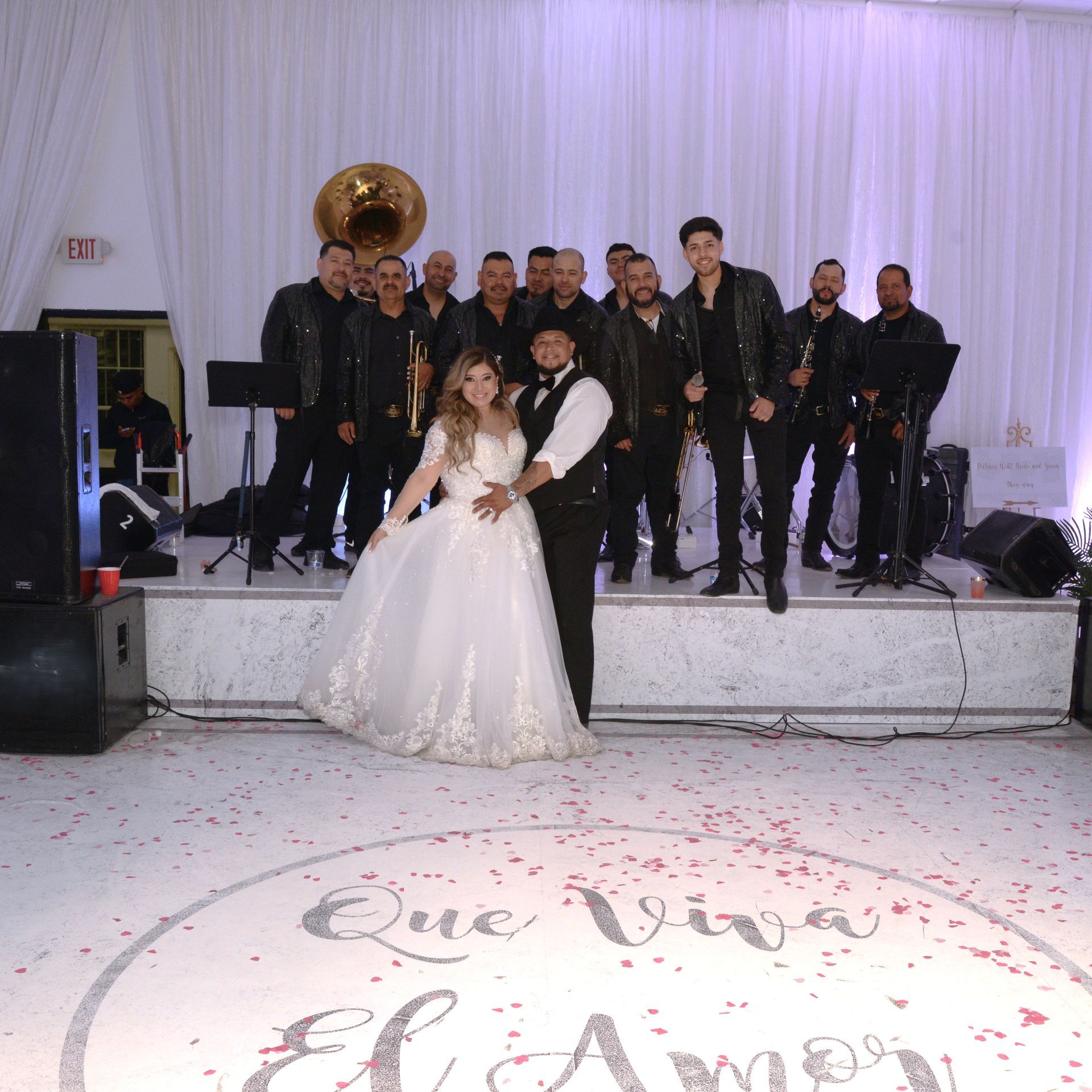 A woman is taking a picture of a bride and groom walking down the aisle at a wedding.