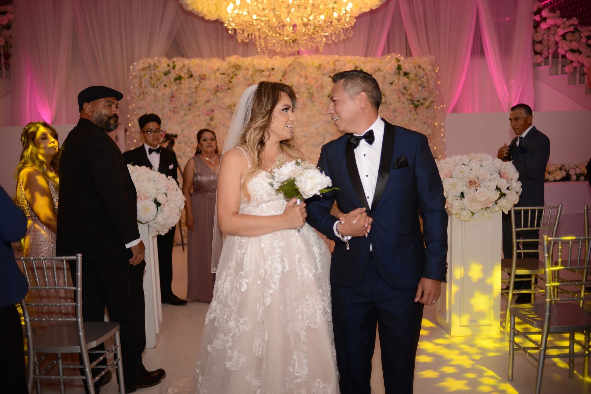 A bride and groom are walking down the aisle at their wedding.