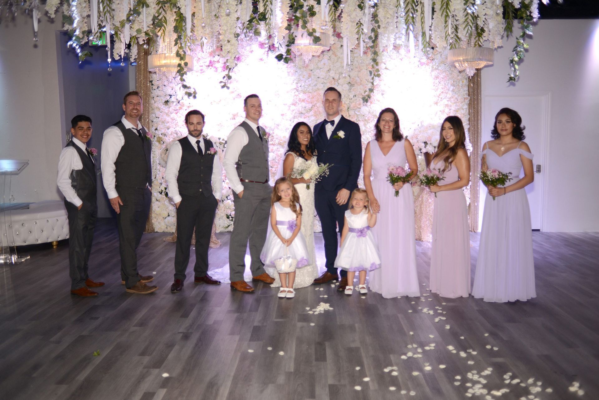 The bride and groom are posing for a picture with their wedding party.