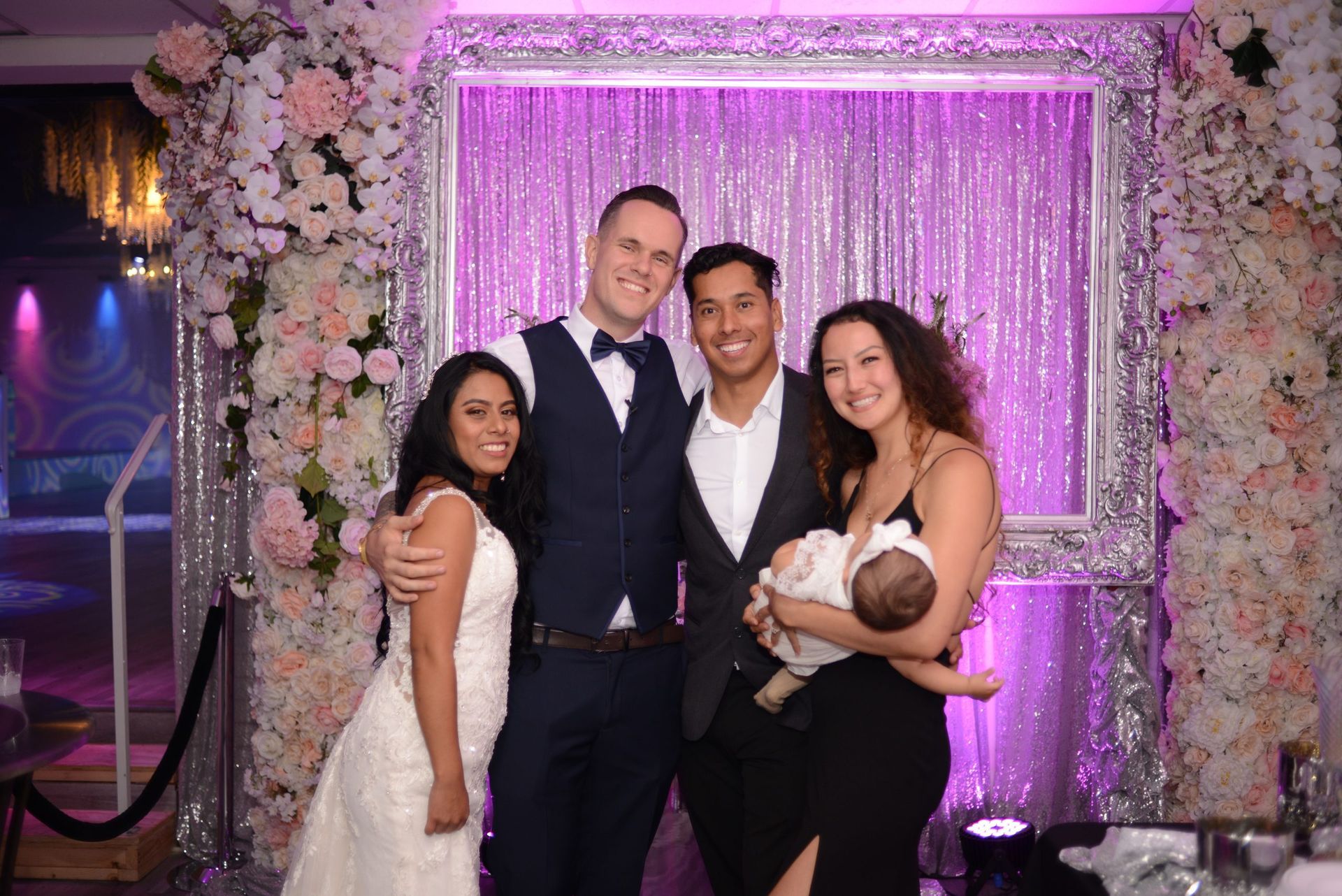 A group of people are posing for a picture at a wedding reception.