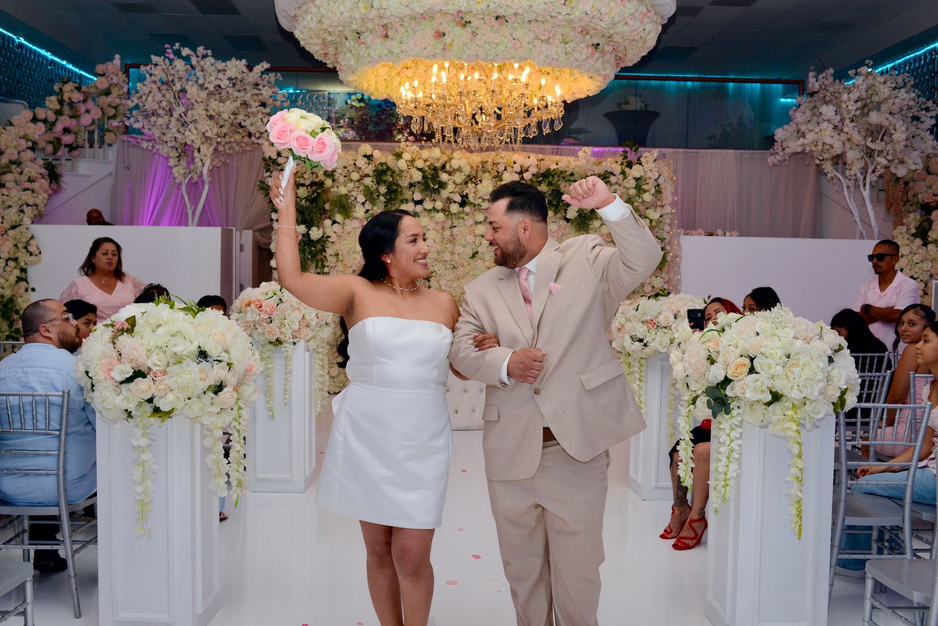 A bride and groom kissing in front of purple flowers