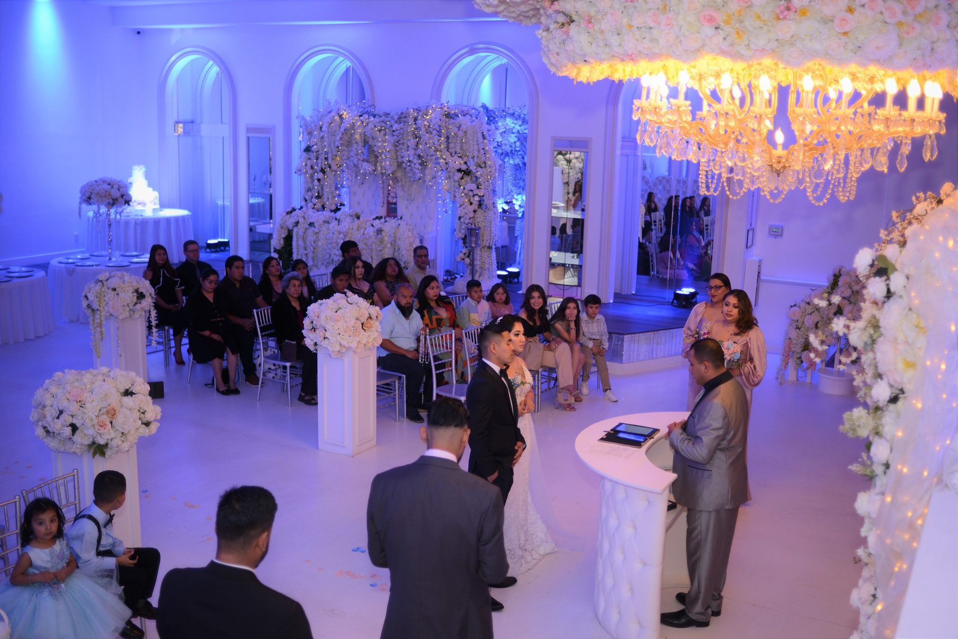 A bride and groom are standing in front of a crowd at a wedding ceremony.